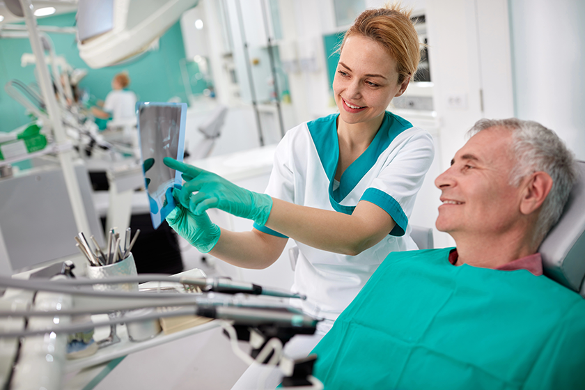 Dentist showing teeth problem on dental X-ray 