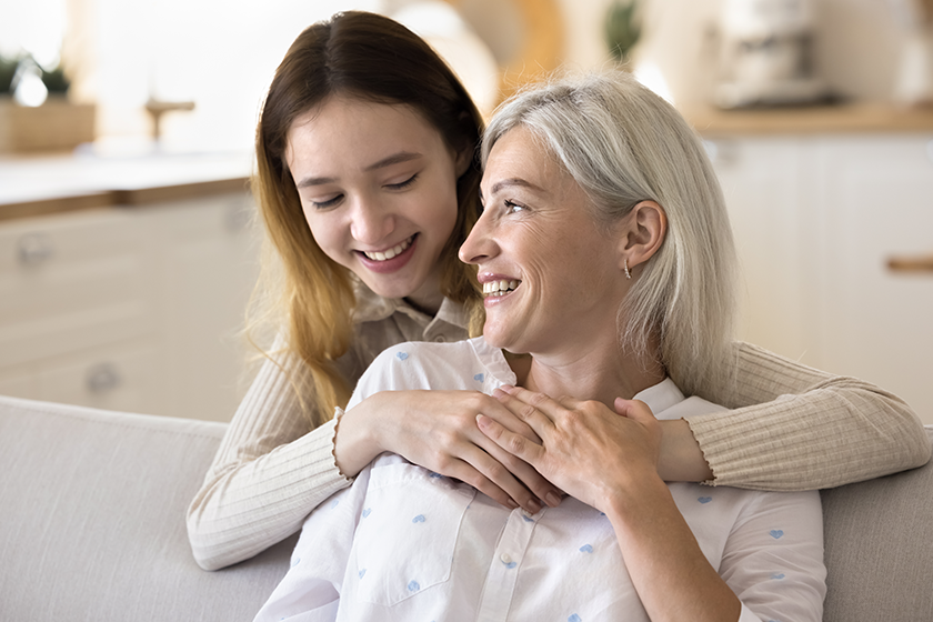 Happy teenager daughter hugs mature mom with love, express tenderness and support. Smiling mum enjoy leisure together with teen girl, having warm relationship, understanding. Mother Day, motherhood