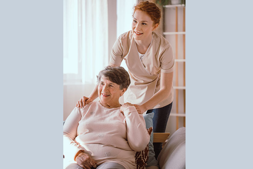 Young caregiver helping an older woman in the nursing house